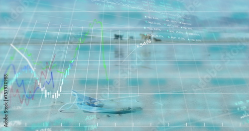 Image of trading board and graphs over close-up on mask and dogs playing on beach