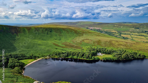 Perched atop the peak, Lough Bray Lower emerges like a sapphire amidst the emerald landscape of the Wicklow Mountains.