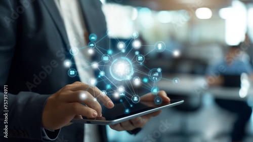 Businessman holding a tablet with glowing futuristic high tech HUD