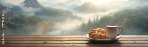: A cup of coffee and croissants lie on the wooden window sill by the window overlooking the big mountains and forest.