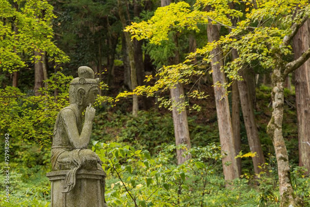 日本　滋賀県東近江市にある湖東三山の一つ、百済寺の弥勒半跏石像と紅葉