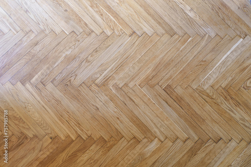Parquet with herringbone background. Wooden floor with a chevron pattern in the living room of the designer interior