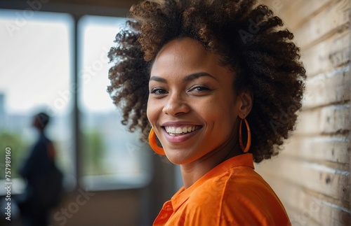 black smiling woman with curly hairs in interior of office or house 