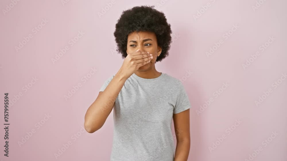 Shocked african american woman in t-shirt peeks through fingers! afraid yet fun, standing against an isolated pink background, covering eyes with hand. Shocked african american woman in t-shirt peeks through fingers! afraid yet fun, standing against an isolated pink background, covering eyes with hand.