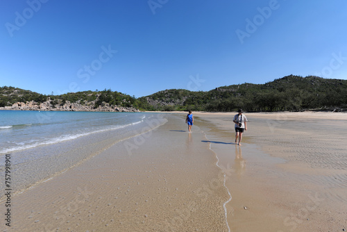 Two people walking on beautiful beach, Florence Bay, QLD, Australia