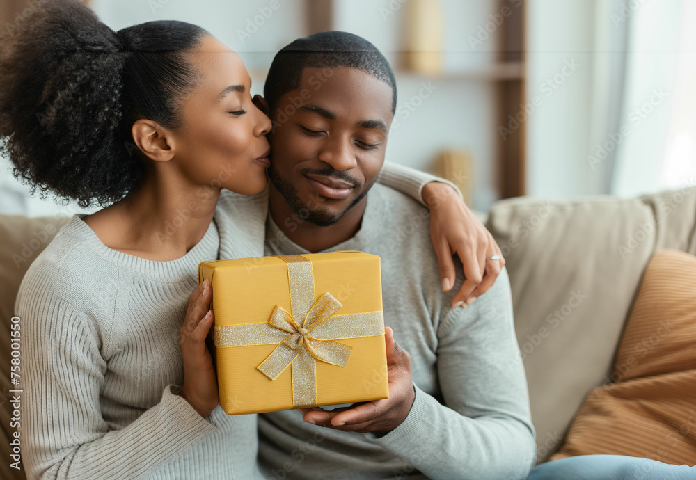 Joyful Embrace: African American Couple Sharing a Heartfelt Moment with a Festive Gift - obrazy, fototapety, plakaty 