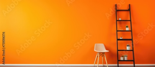 Designer sitting on ladder next to fresh orange wall, room for text photo