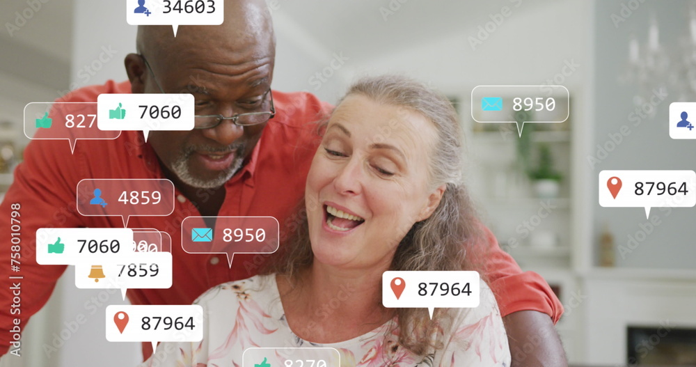 Φωτογραφία Image of social media icons and numbers over senior diverse couple at home