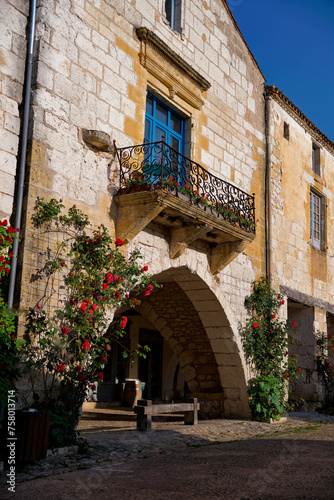 Fototapeta Naklejka Na Ścianę i Meble -  Beautiful stone house with blue shutters and balcony in Monpazier, Dordogne, Nouvelle-Aquitaine