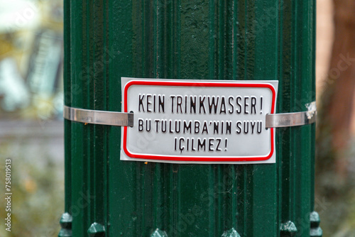 Non drinkable water sign plate in German and Turkish languages on an ancient water fountain in Nikolaiviertel, Berlin, Germany photo