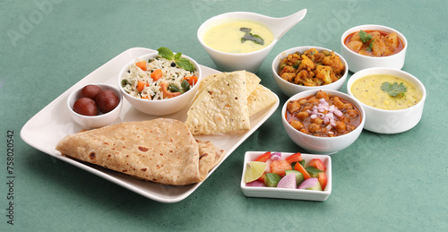 Assorted indian food for lunch or dinner, rice, lentils, paneer butter masala, palak panir, dal makhani, naan, green salad photo