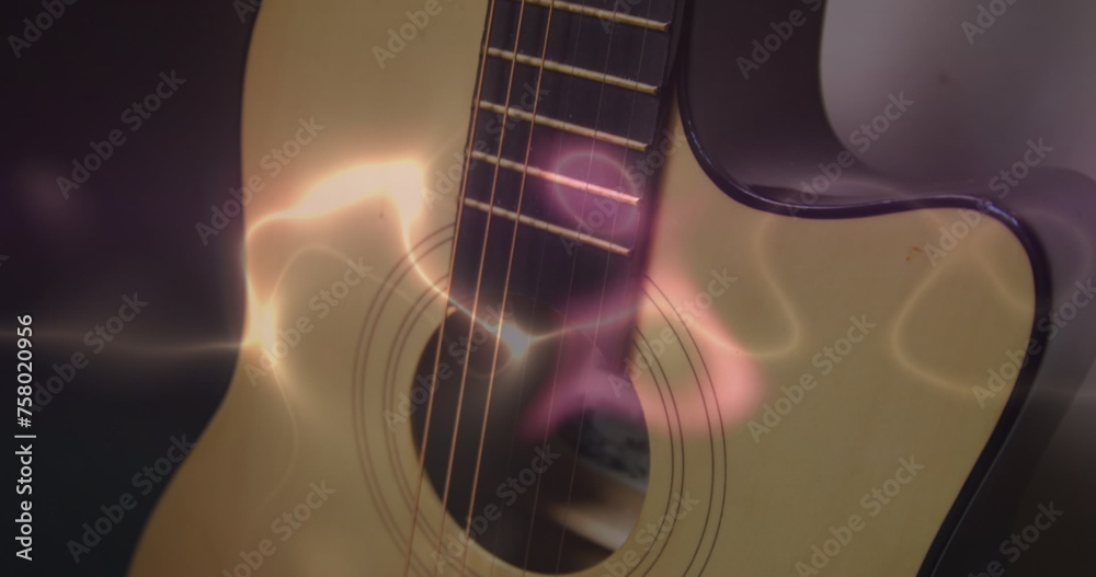 Naklejka premium Image of white, blue and pink light trails over acoustic guitar on smokey background