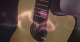 Image of white, blue and pink light trails over acoustic guitar on smokey background