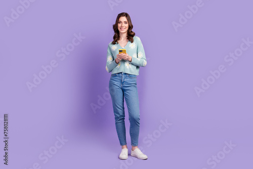 Full length photo of positive pretty woman wear print cardigan chatting instagram twitter telegram facebook isolated purple color background