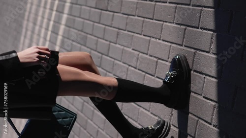 Woman legs wearing penny loafers and black socks walking on the street