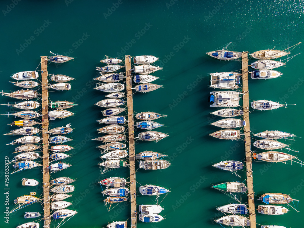 Aerial top view by drone of boats and yachts in mediterranean harbor. View in summer sunny day.