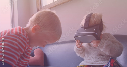 Image of smiling caucasian siblings playing with vr headset