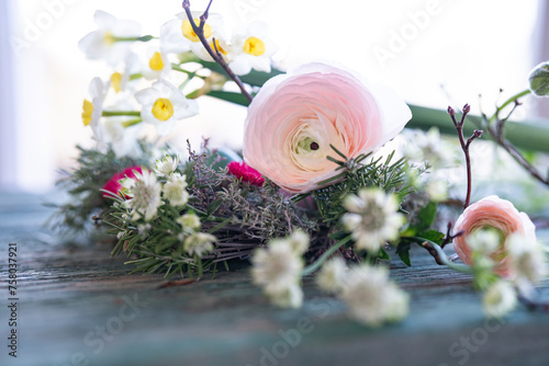 Spring floristry with herbs and flowers on weathered wood. Natural spring decoration with short depth of field.
