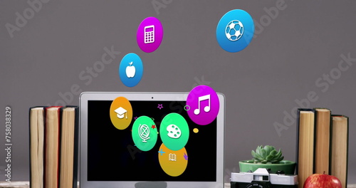 Image of colorful icons over laptop on desk