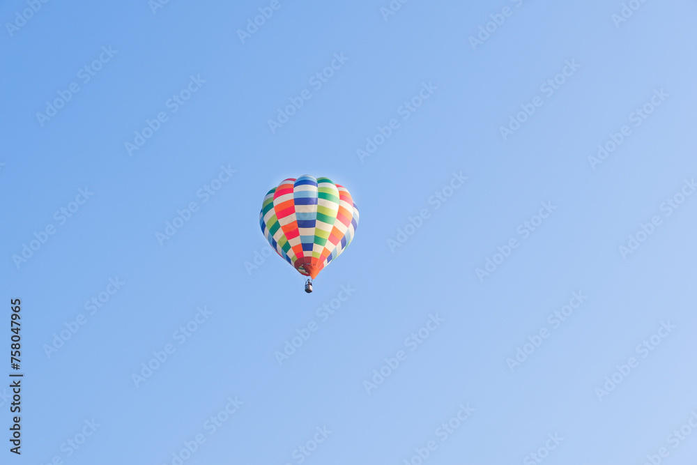 Hot air balloons landing in a mountain flight over field and forest,colorful Hot air balloons flying over the valley with blue sky,Tourism concept. Hot air balloons landing in a mountain flight over field and forest,colorful Hot air balloons flying over the valley with blue sky,Tourism concept.