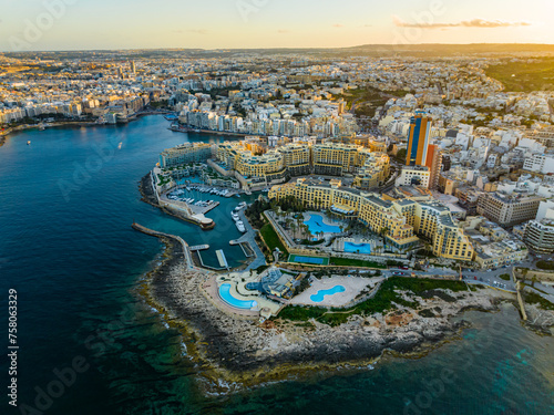 Drone view of St. Julian's city and high buildings. Sunset sky. Malta island