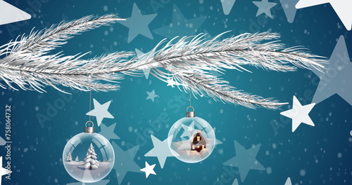 Image of christmas bubbles and stars with snow falling on blue background
