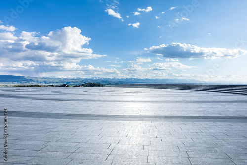Empty square floor and mountains with sky clouds background © ABCDstock