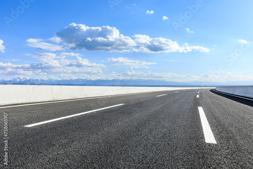 Asphalt highway road and mountains with sky clouds background