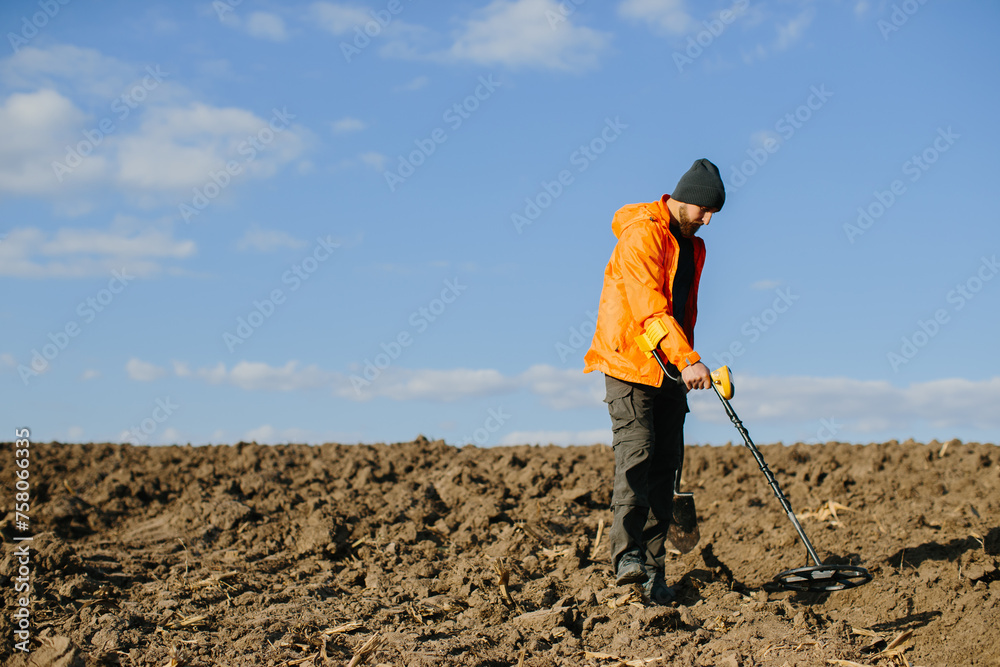 Man with a metal detector in the field. Search for treasures.