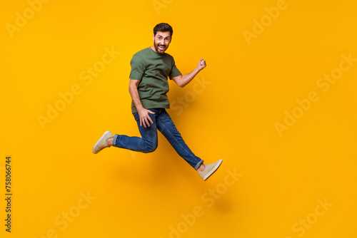 Full body photo of attractive young man jump raise fist celebrate winning wear trendy khaki clothes isolated on yellow color background © deagreez