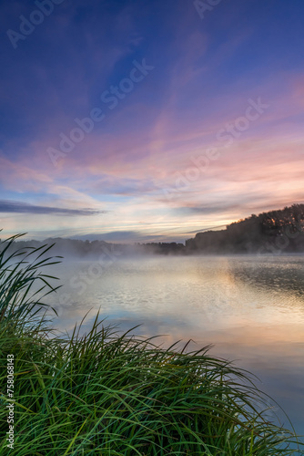 Dawn landscape on the lake. Early foggy mornings with beautiful skies and clouds. The colors of dawn and fog.