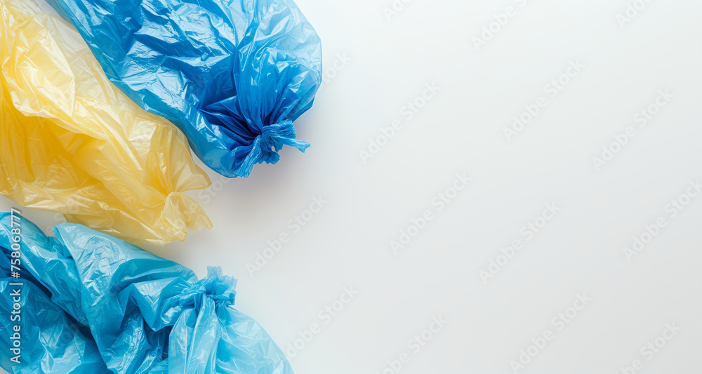 Fototapeta premium Multi-colored full garbage plastic bags on white background with copy space. Concept of environmentally friendly redistribution of waste
