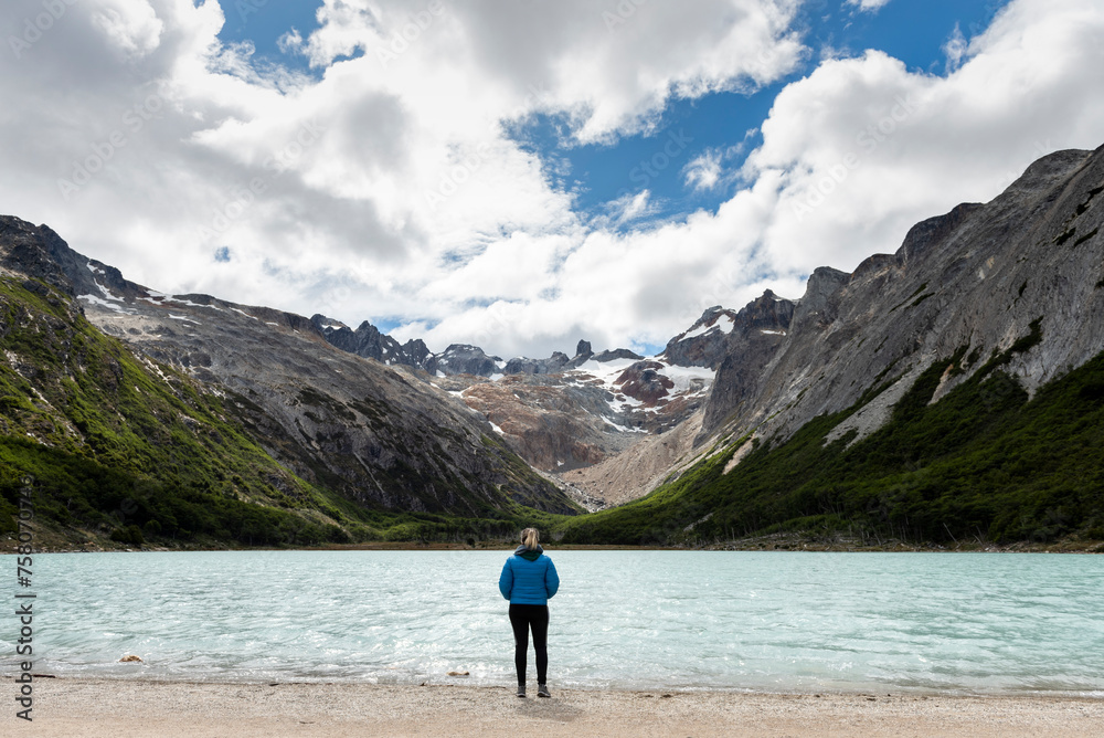 woman contemplating and walking through beautiful landscape of mountains forests rivers and bridges lifestyle of traveling ushuaia argentina end of the world