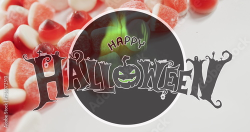 Happy halloween text banner against close up of candy corns on white surface