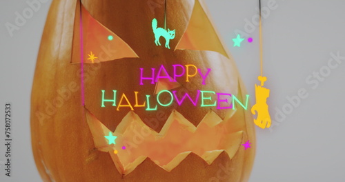 Neon happy halloween text banner over halloween scary pumpkin against grey background