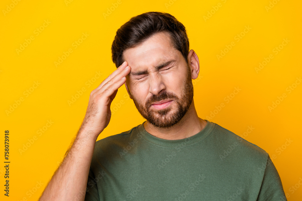 Photo of stressed depressed guy dressed green t-shirt arm head feeling pain isolated yellow color background Photo of stressed depressed guy dressed green t-shirt arm head feeling pain isolated yellow color background