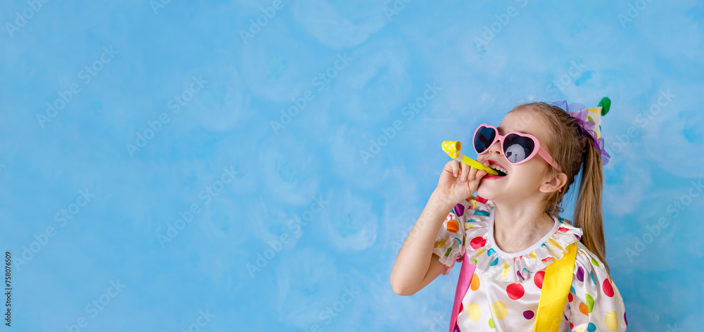Funny kid clown playing against a bright wall. 1 April Fool's day concept, birthday concept. Copy space for text