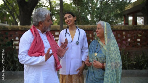Beautiful Indian lady doctor chatting happily with her parents - proud parents  wellness concept  senior doctor. Panchayat hospital doctor posing with patients - government doctor  studious kid  to... photo