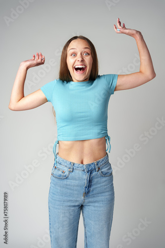 Happy cute young beautiful woman looking excited and surprised on gray background