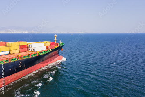 Aerial top down view of a bow of large container cargo ship cruising with speed in sea