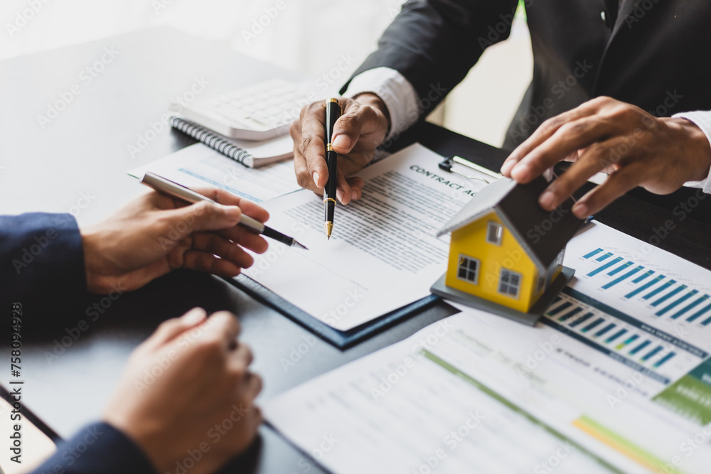 Real estate agents and business people discuss signing a home purchase agreement and home insurance. Real estate agents and business people discuss signing a home purchase agreement and home insurance.