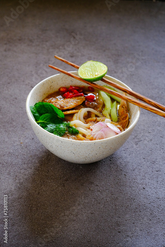 laksa ikan, asam laksa, rice noodle,vegetables, filet fish with sour soup, popular in penang, malaysia