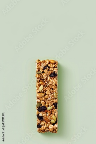 Strawberry, oat and nut bar isolated on green background photo