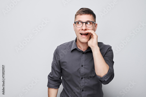 Portrait of handsome man shouting loudly with hands, news, palms folded like megaphone isolated on white background