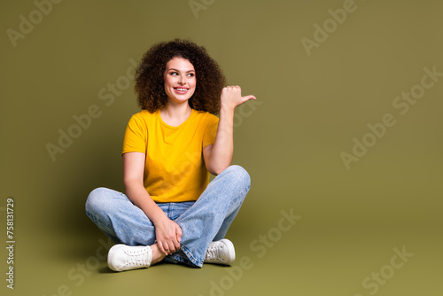 Full length photo of smiling model brunette curly curls hair woman point finger best spa salon in city isolated on khaki color background