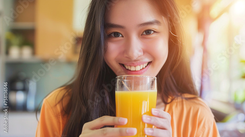 Young woman drinking orange juice in the morning. 