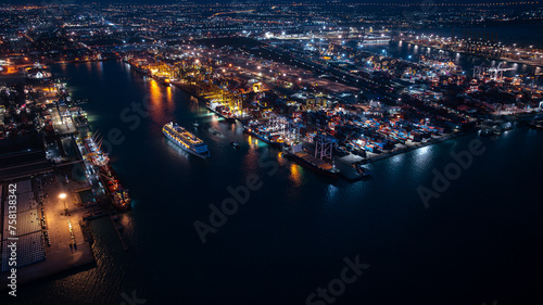large cruise ship departing from Laem Chabang Port at night.  want to use low shutter speed to see movement of the ship. blue tone and over lighting scene photography aerial view. photo