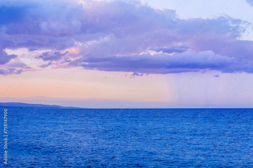 Obraz premium scenic blue seascape of sunset or sunrise above water with beautiful colorful evening clouds