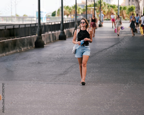 Young man walking outdoors on the seaside promenade. Concept: lifestyle, fashion, style