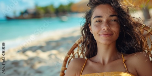 Portrait of a smiling woman resting in a deckchair on the beach. Summer landscape in background. photo